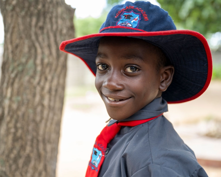 David smiling in his school hat after cleft surgery